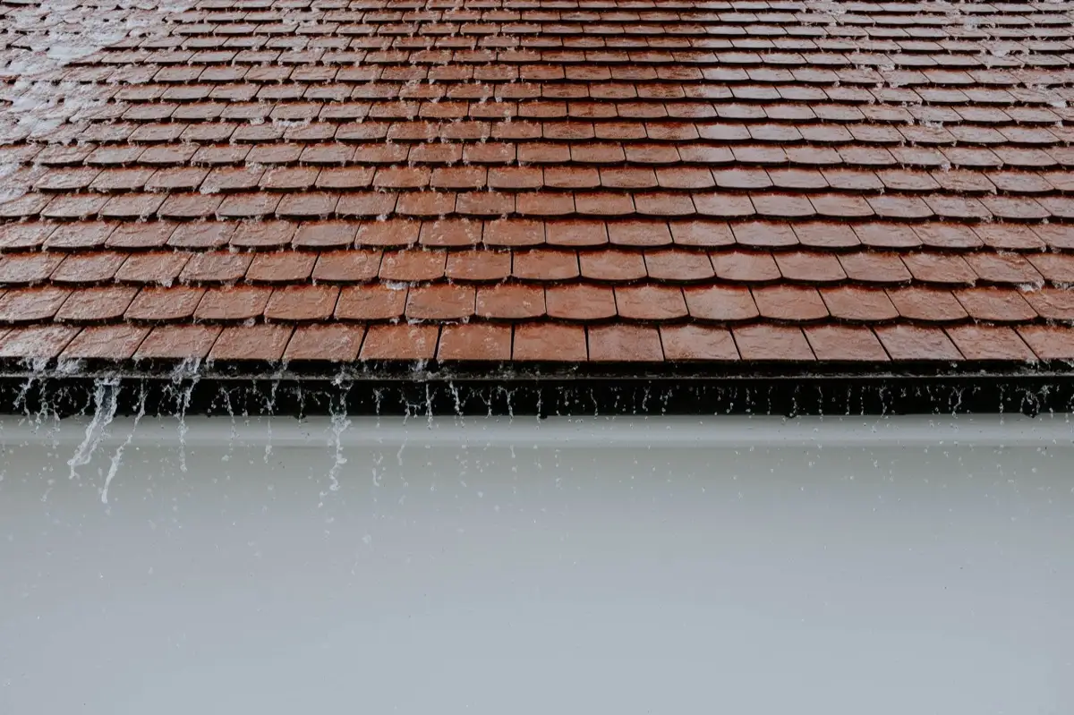 Rainwater running off a roof edge into a seamless K-style gutter in Yonkers, NY